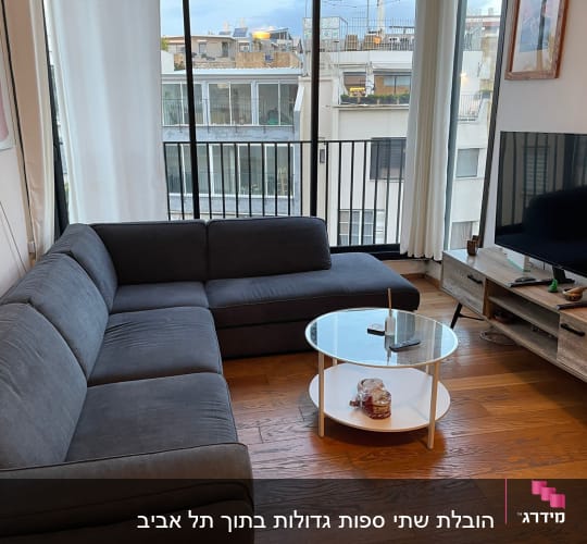 סלון עם ספה, שולחן עגול וטלוויזיה על מזנון